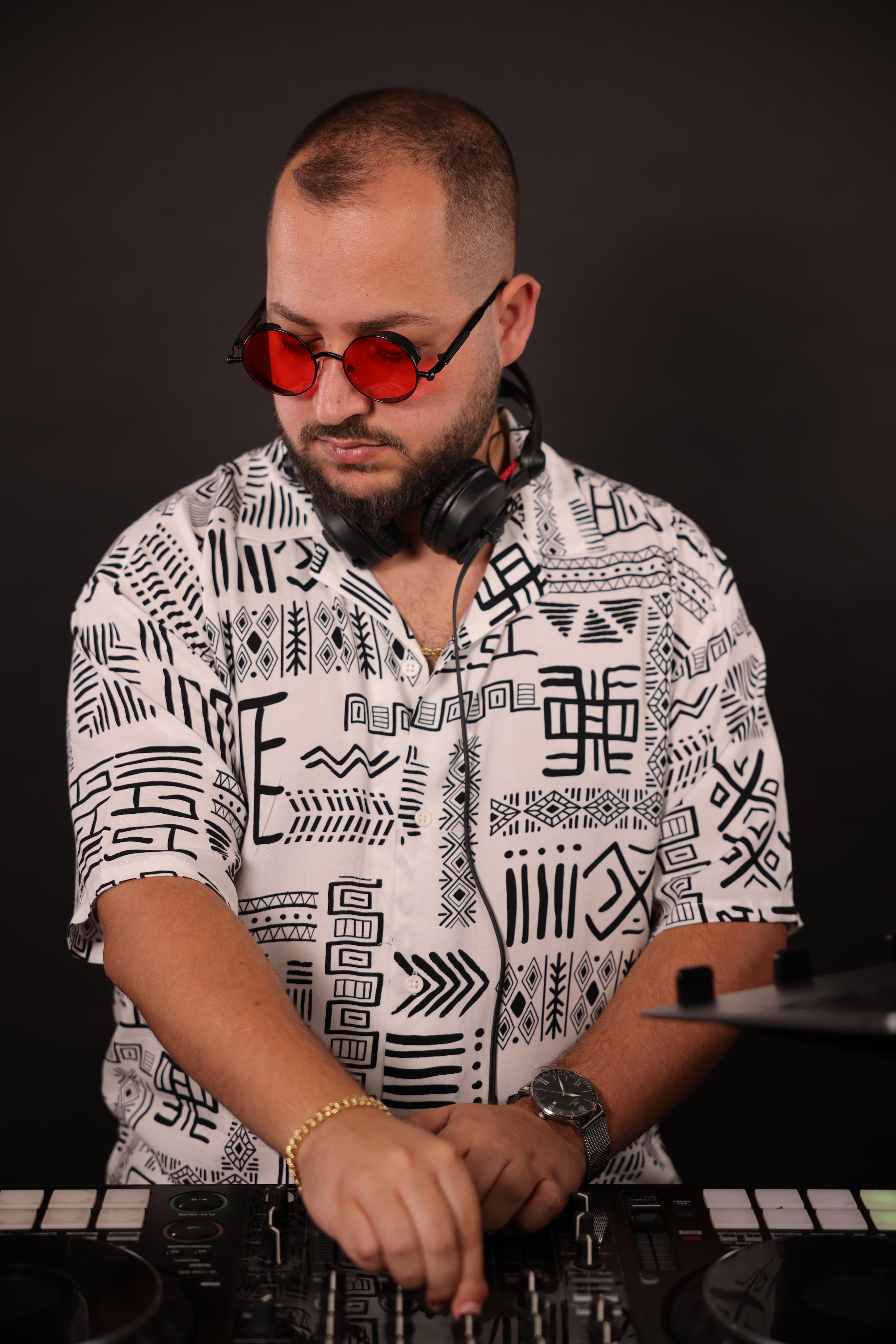 DeeJoe at the decks, wearing red sunglasses and headphones