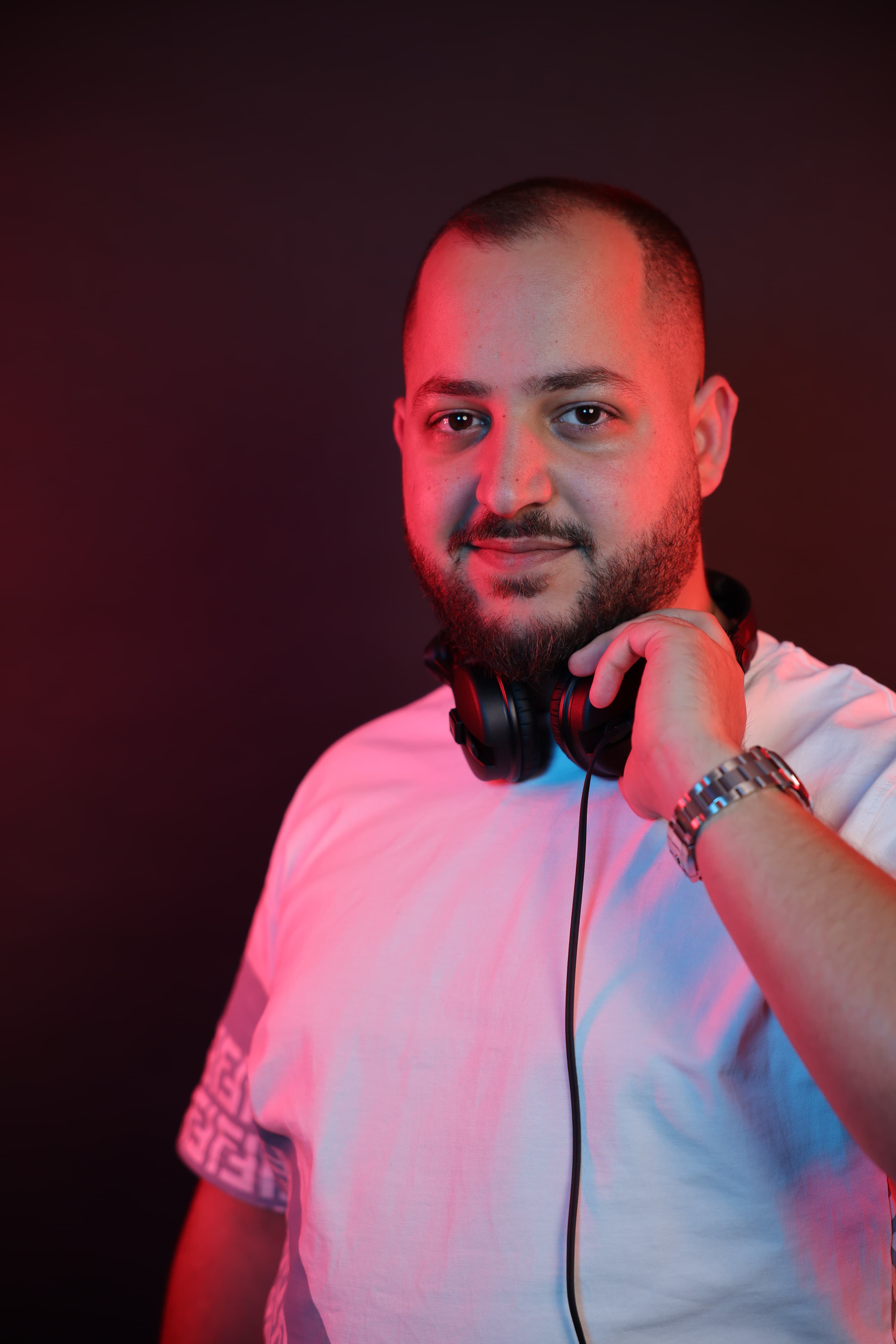 DeeJoe wearing headphones under red and blue lighting