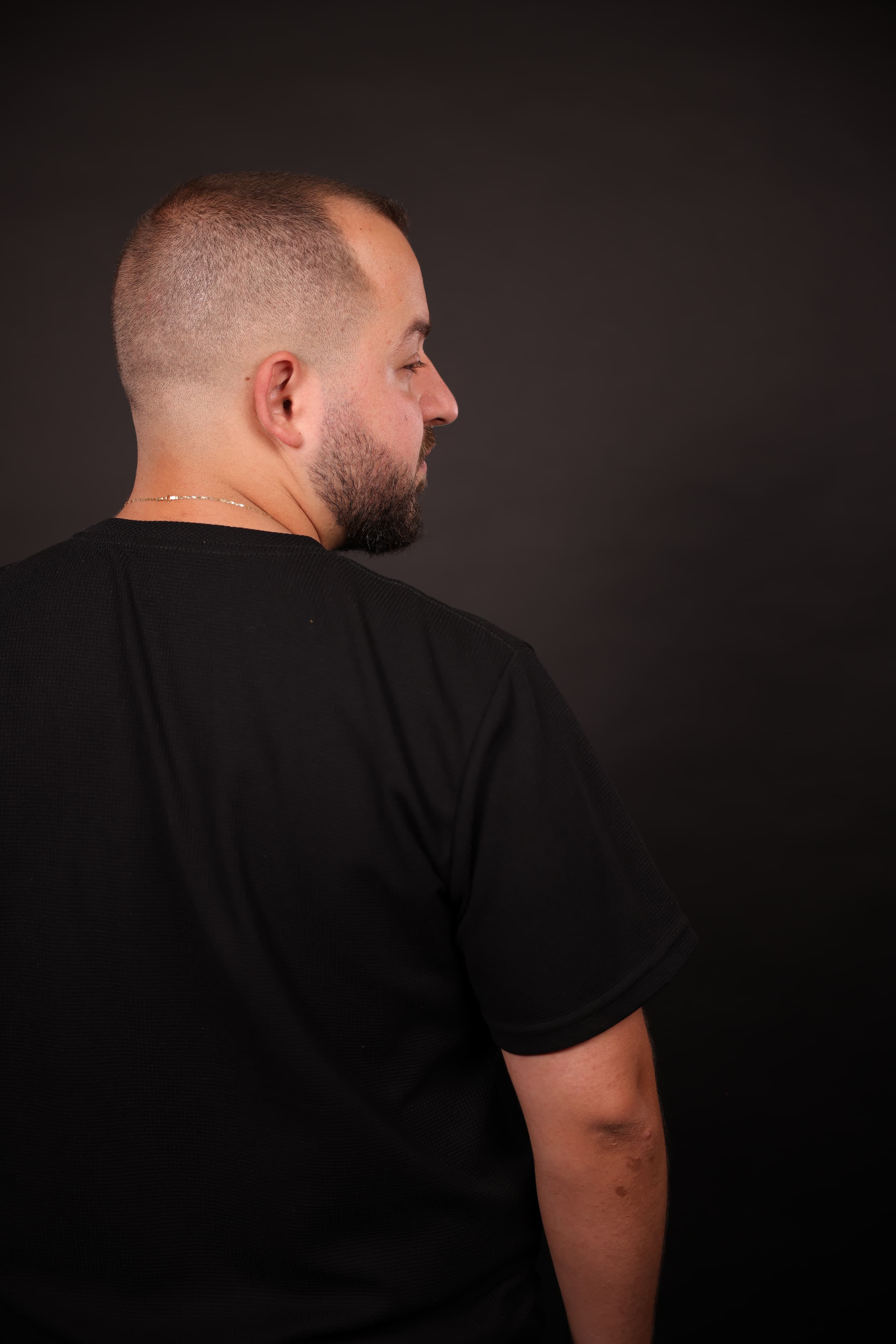 DeeJoe in a black T-shirt, photographed in profile